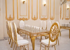 Gold chairs around a glass dining table