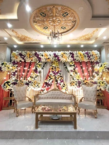 Colourful floral arch stage with silver seating