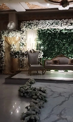 Green wall stage with marble floor and flower runner