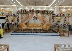 Wide view of a bridal stage with floral drapes and gold sofas